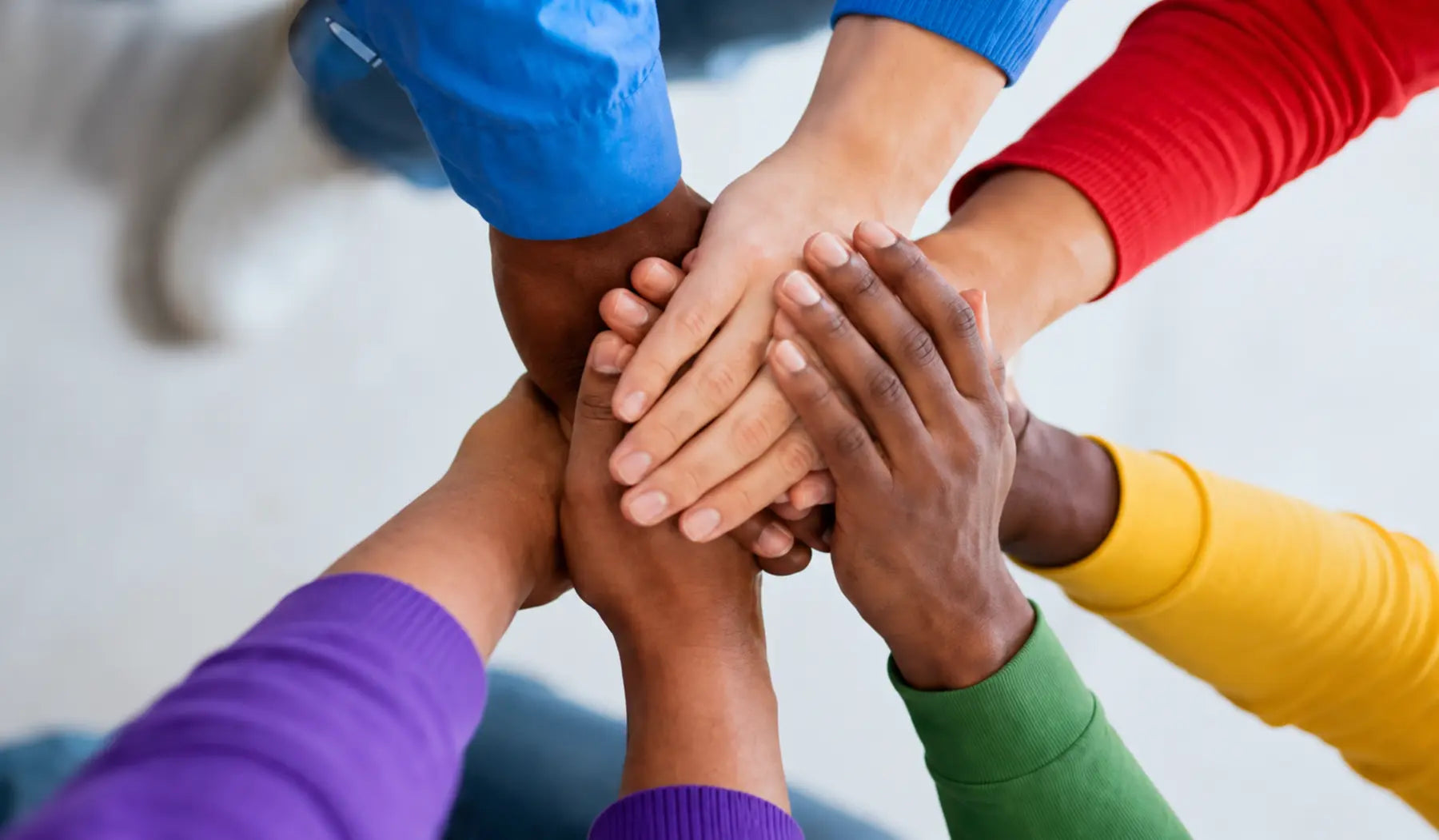 A diverse community joining hands in support